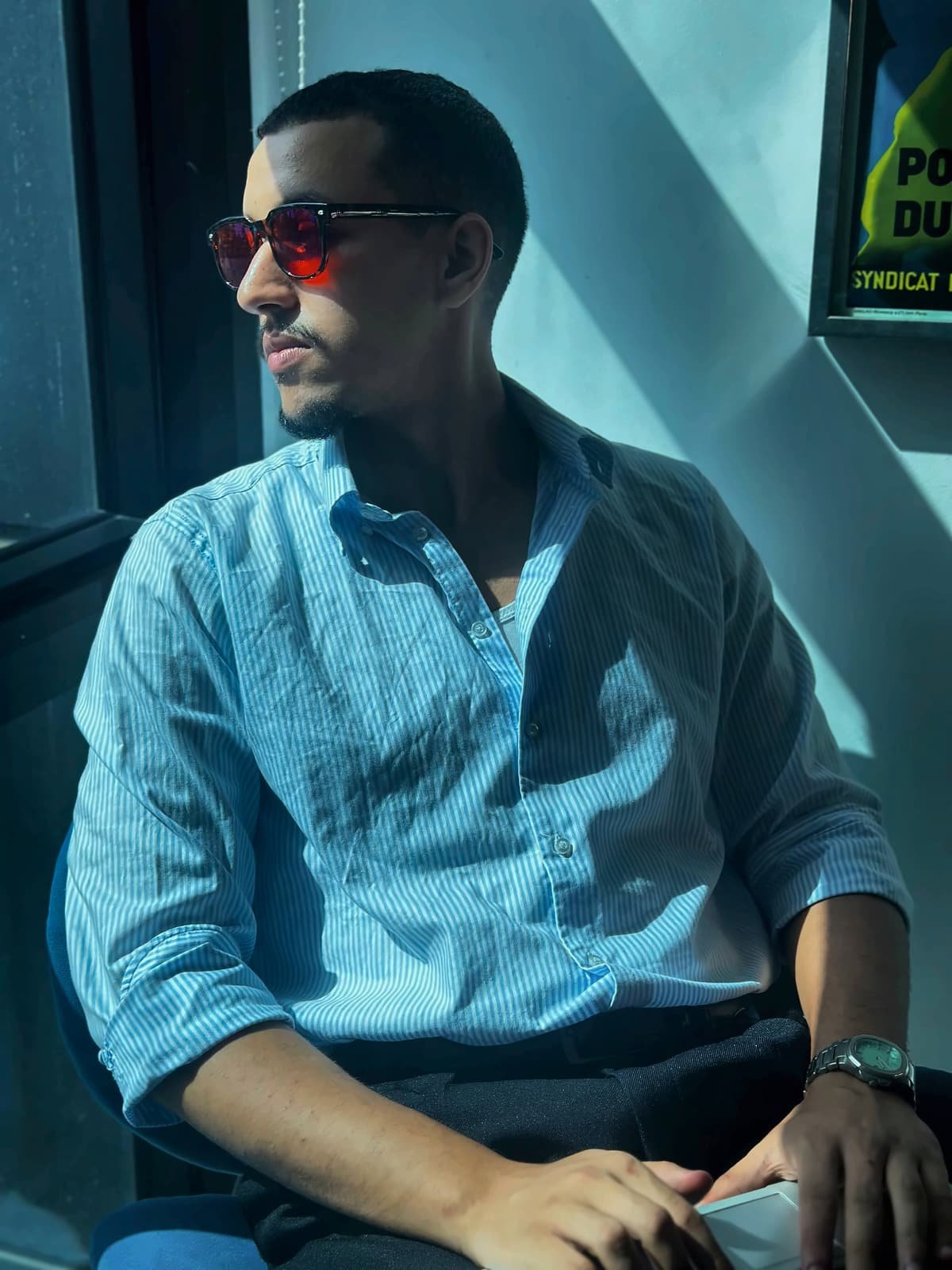 Homme en chemise bleue au soleil, portant des lunettes Bleuvex Noctis aux verres rouges