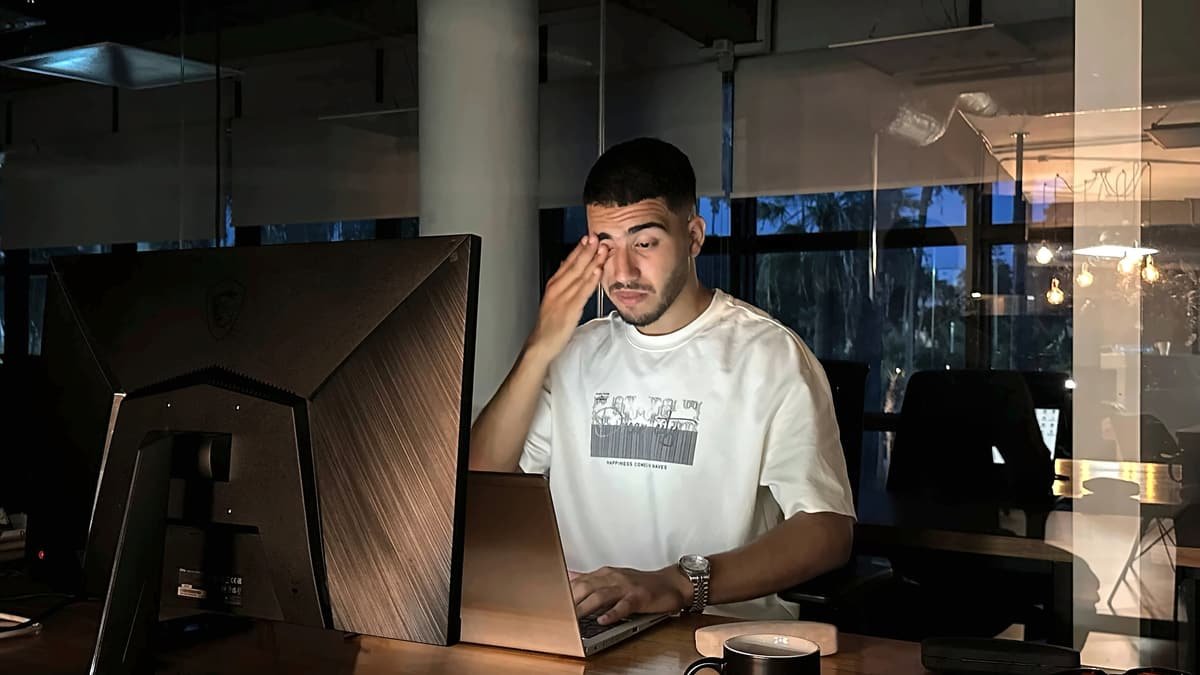 Homme se frottant les yeux devant son ordinateur portable le soir, sans lunettes
